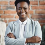 Portrait of happy black female leader and her business team at corporate office.